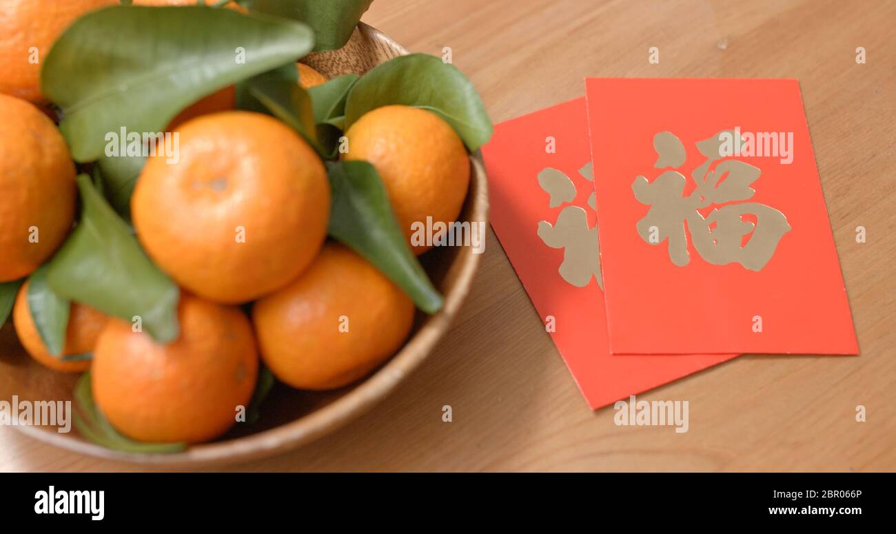 Orange mandarin pour le nouvel an lunaire avec paquet rouge mot chinois signifie chance Banque D'Images
