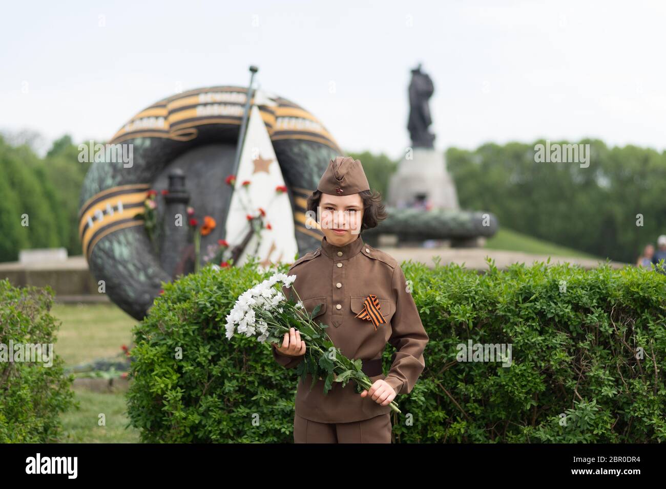 Portrait d'un garçon avec des fleurs, de l'uniforme d'un soldat de l'Armée rouge pendant la Seconde Guerre mondiale. Monument commémoratif de guerre soviétique (parc de Treptow), Berlin, Banque D'Images