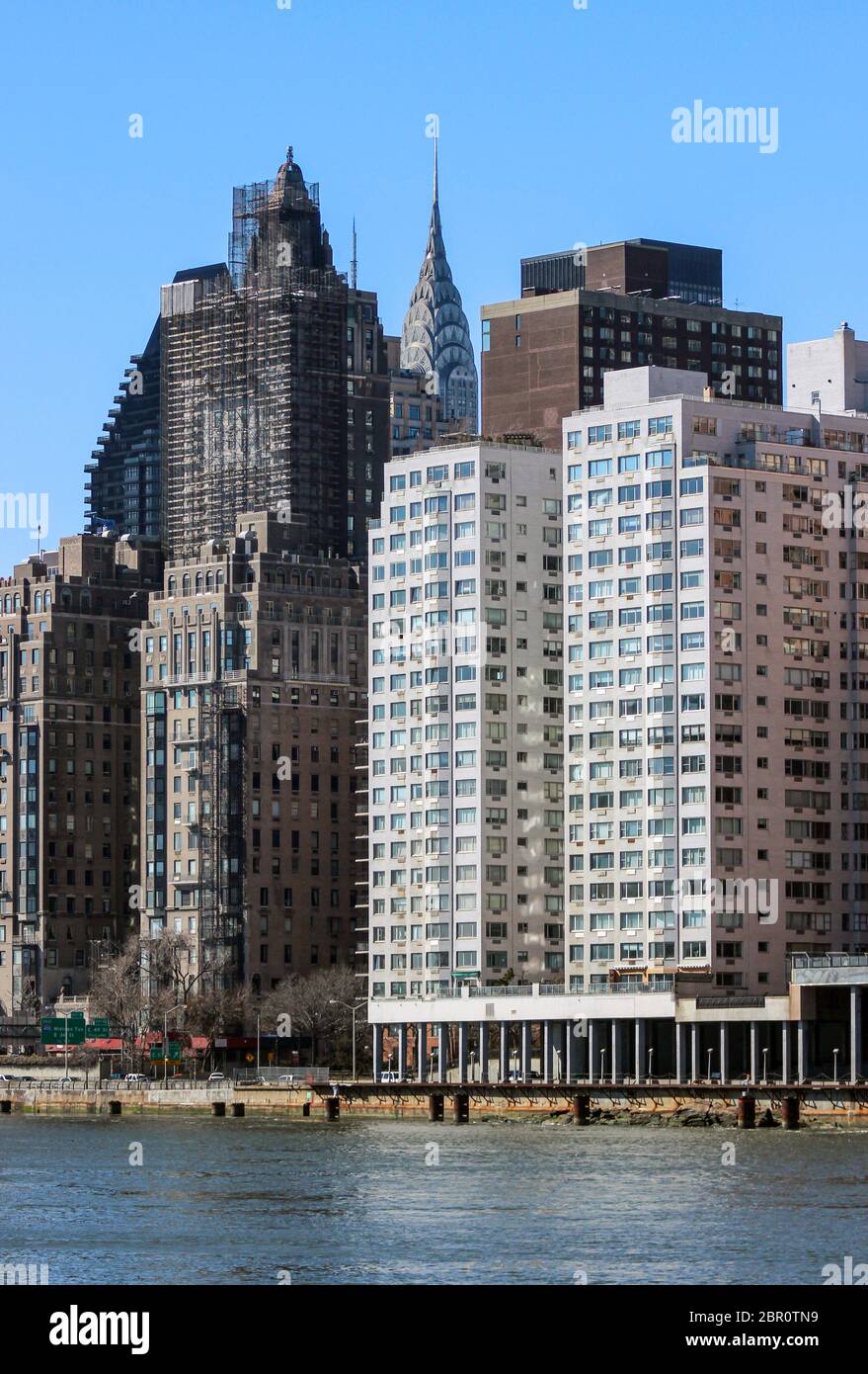 La couronne du Chrysler Building se trouve derrière les bâtiments de la rivière East River, à New York, aux États-Unis Banque D'Images