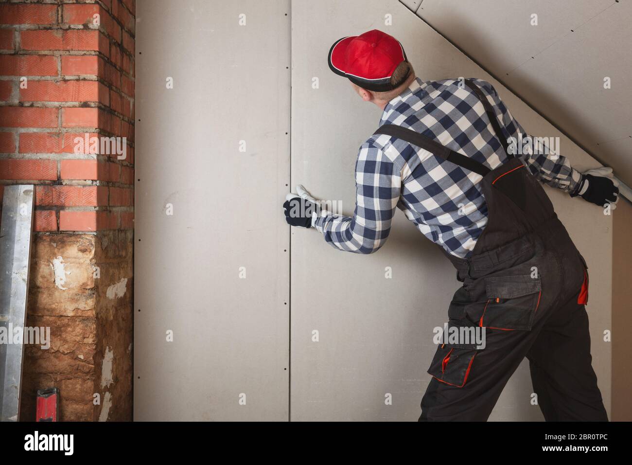 L'installation de l'homme fiche de plâtre au mur pour construction chambre mansardée Banque D'Images