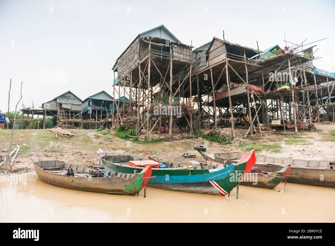 Bateaux sur la rivière avec des maisons sur pilotis en arrière-plan à Kampong Phluk, province de Siem Reap, centre-nord du Cambodge, Asie du Sud-est Banque D'Images