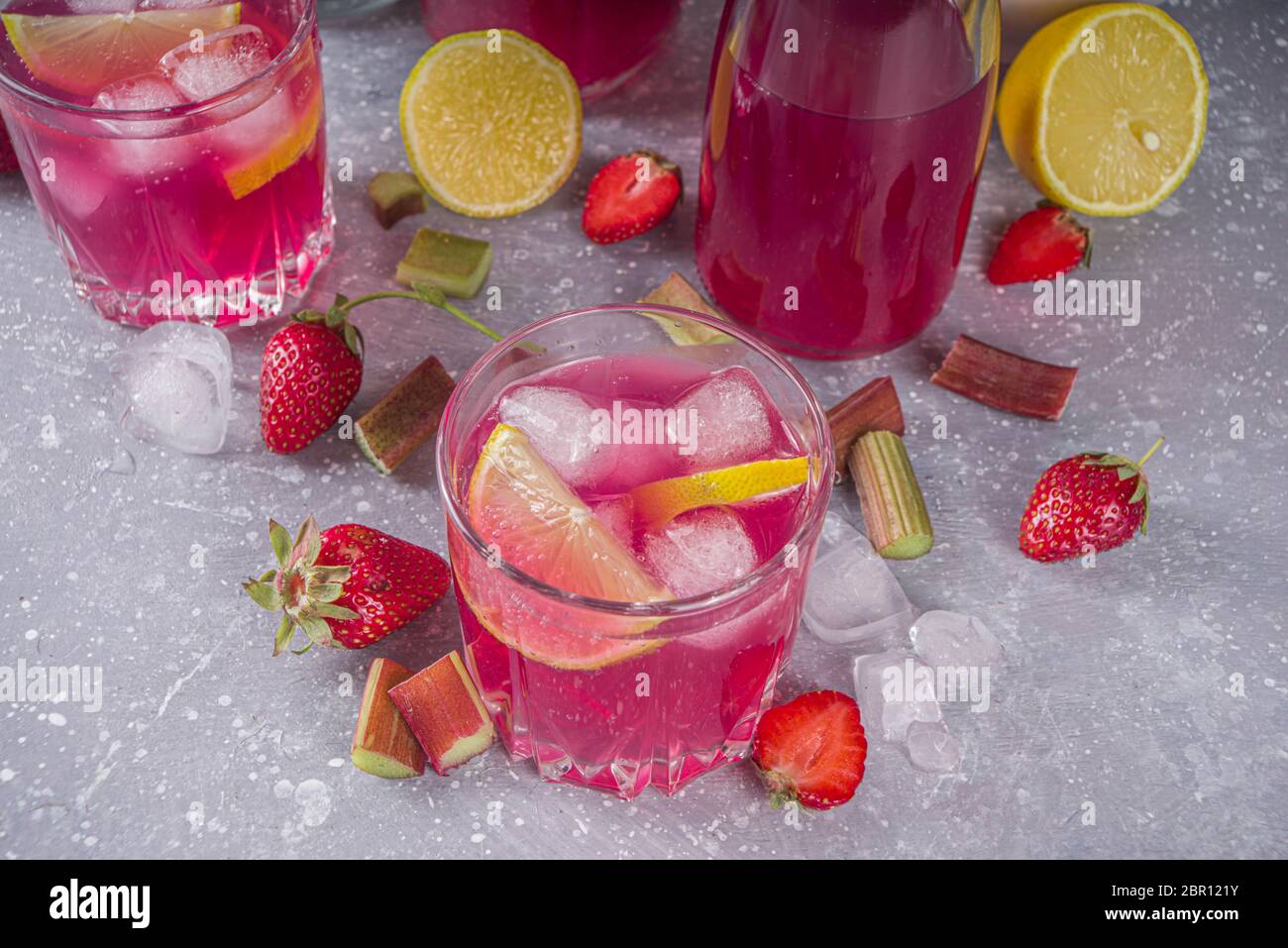 Rhubarbe maison et cocktail d'alcool aux fraises. Liqueur ou gin de rhubarbe,  sur fond gris avec rhubarbe fraîche, fraises, citron, menthe Photo Stock -  Alamy