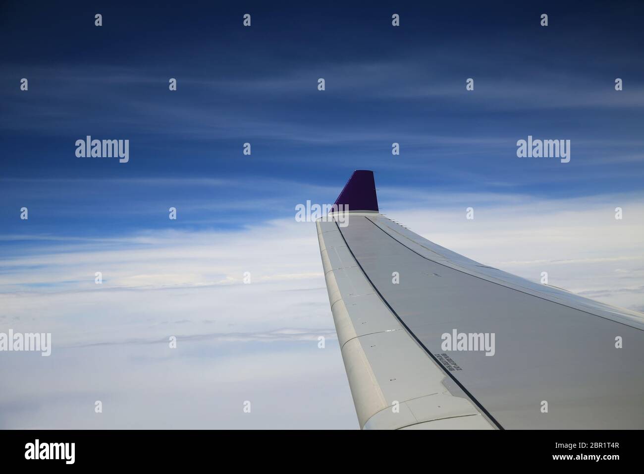 Vue depuis la fenêtre de l'avion sur l'aile sur le nuage blanc et bleu ciel dans la journée ensoleillée. Banque D'Images