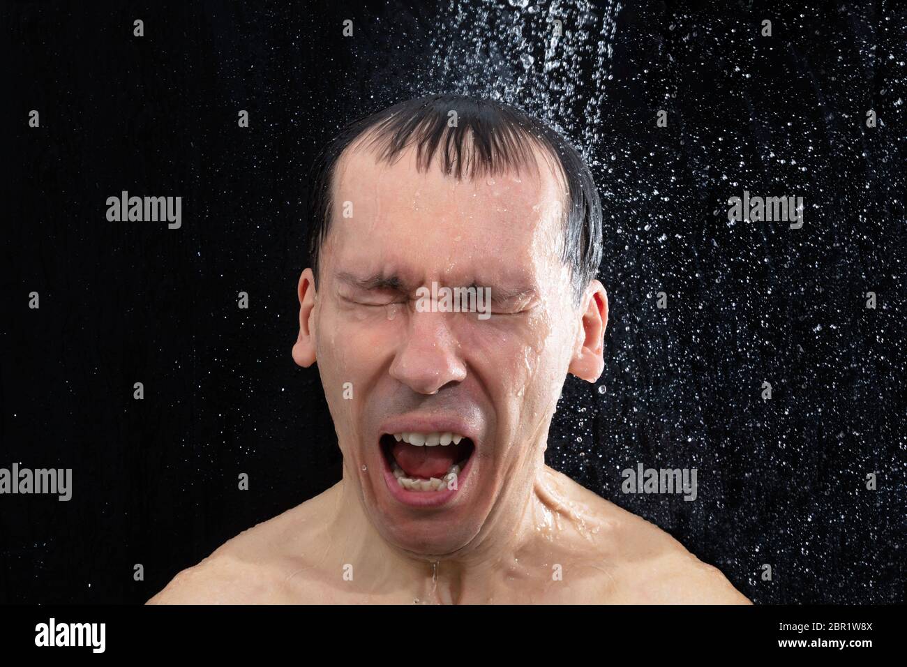 Portrait de jeune homme pris froid douche dans la salle de bains Banque D'Images
