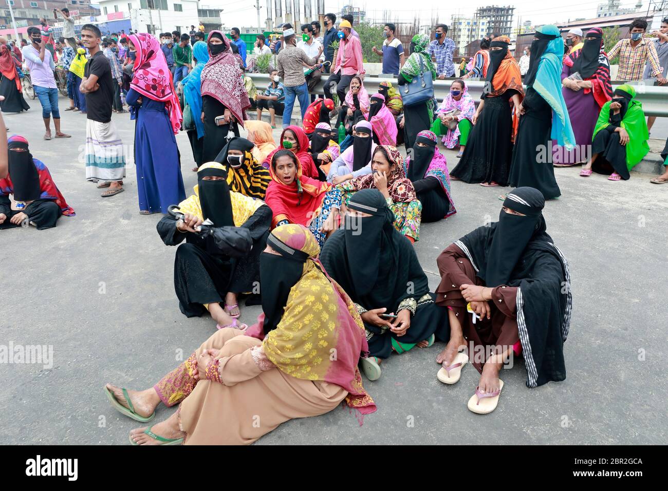 Dhaka, Bangladesh - 20 mai 2020 : les travailleurs du vêtement bangladais bloquent une route lorsqu'ils se rassemblent pour protester contre leurs salaires impayés dans tout le pays Banque D'Images