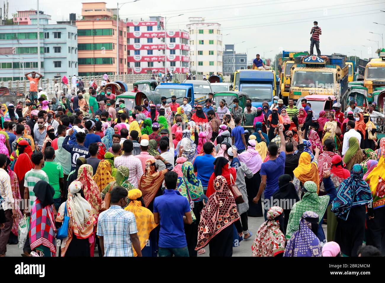 Dhaka, Bangladesh - 20 mai 2020 : les travailleurs du vêtement bangladais bloquent une route lorsqu'ils se rassemblent pour protester contre leurs salaires impayés dans tout le pays Banque D'Images