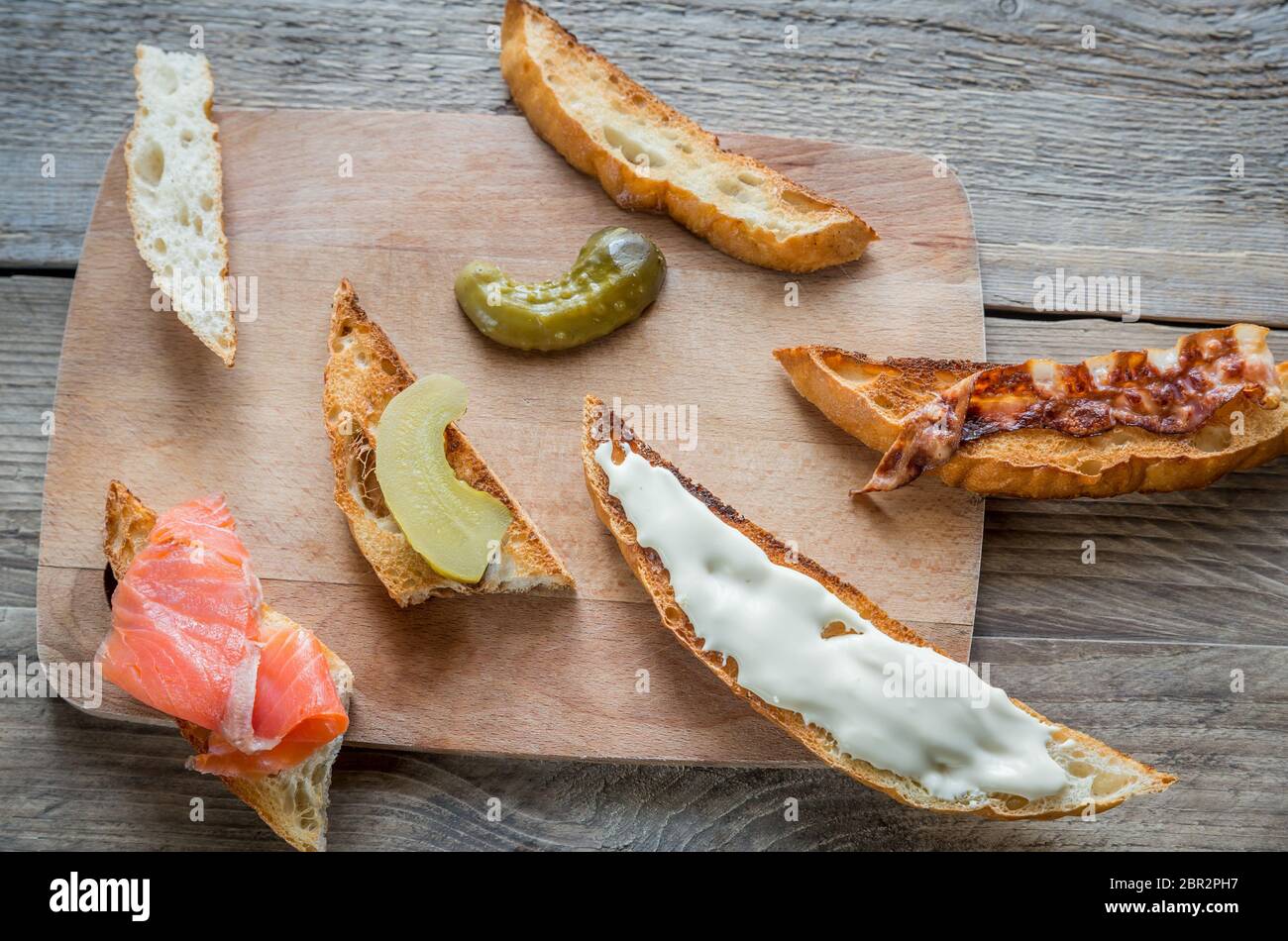 Toasts avec garnitures différentes sur la planche de bois Banque D'Images