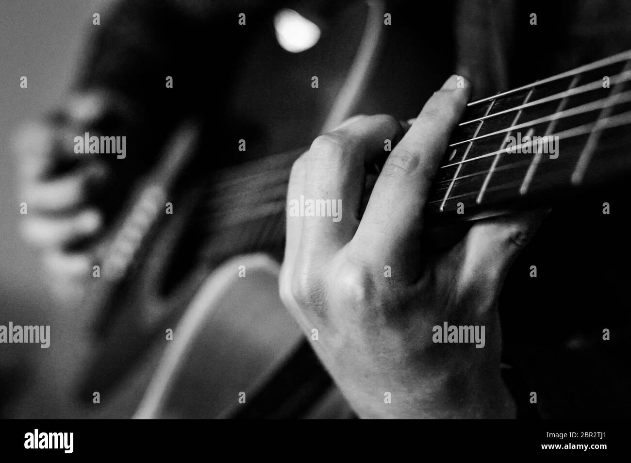 Guitariste accords gros plan sur les cordes - noir et blanc, mise au point sélective. Banque D'Images
