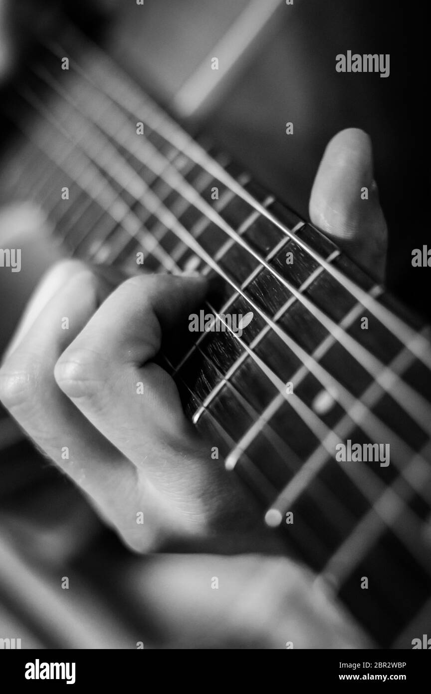 Guitariste accords gros plan sur les cordes - noir et blanc, mise au point sélective. Banque D'Images