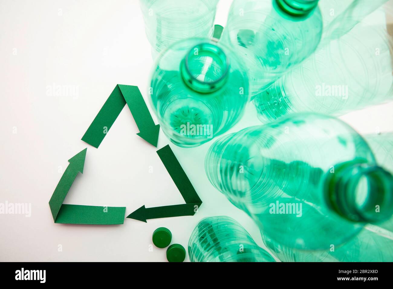 Symbole de recyclage du papier vert avec bouteilles d'eau en plastique vides Banque D'Images