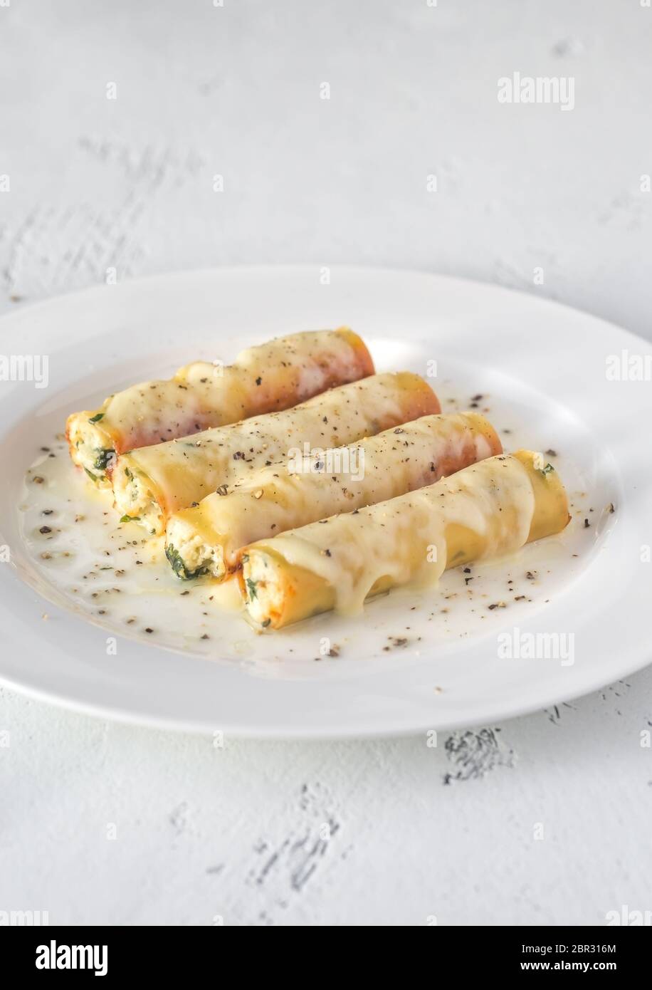 Les Cannelloni farcis au ricotta sur la plaque blanche Banque D'Images