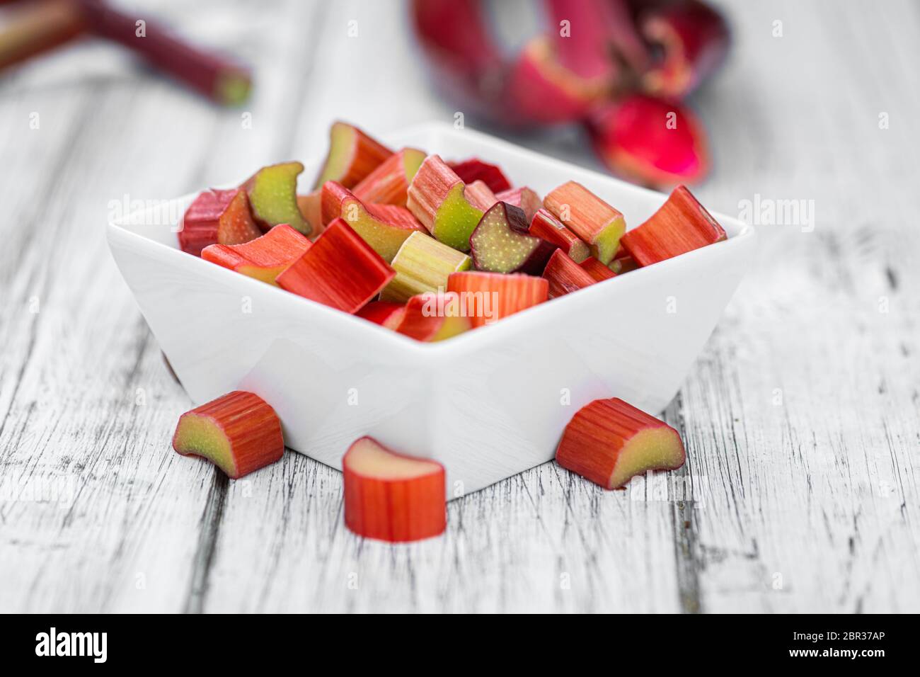 Rhubarb haché sur une ancienne table en bois (gros plan ; mise au point sélective) Banque D'Images