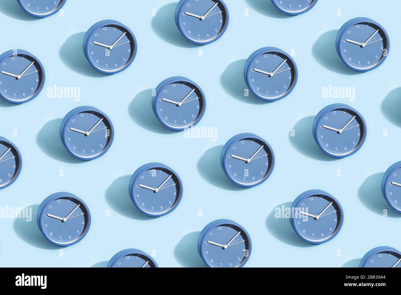 Motif tendance composé d'horloges bleues sur fond bleu pastel. Banque D'Images