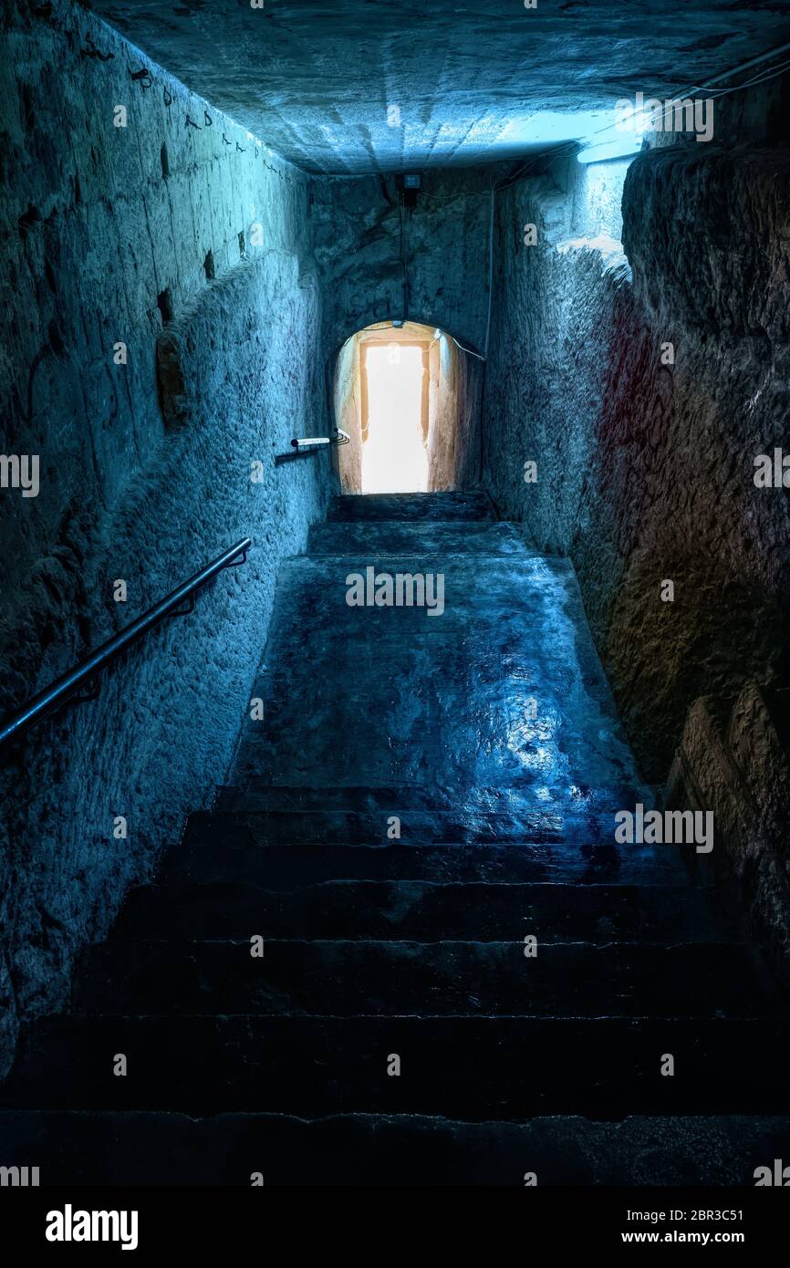 Passage de Glomy avec des escaliers sculptés en pierre avec lumière au bout d'un tunnel, couloir urbain créepy vers le front de mer dans la ville de la Valette, Malte Banque D'Images