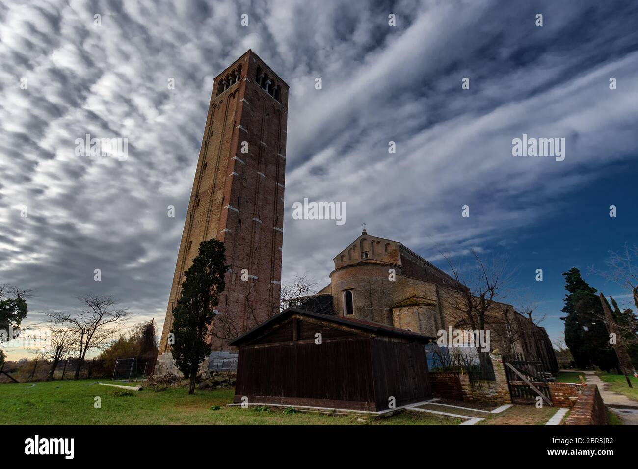 Vue sur la cathédrale de Torcello (basilique de Santa Maria Assunta), l'église de Santa Fosca et le clocher, sur des arbres verts sous ciel bleu, sur l'île Banque D'Images