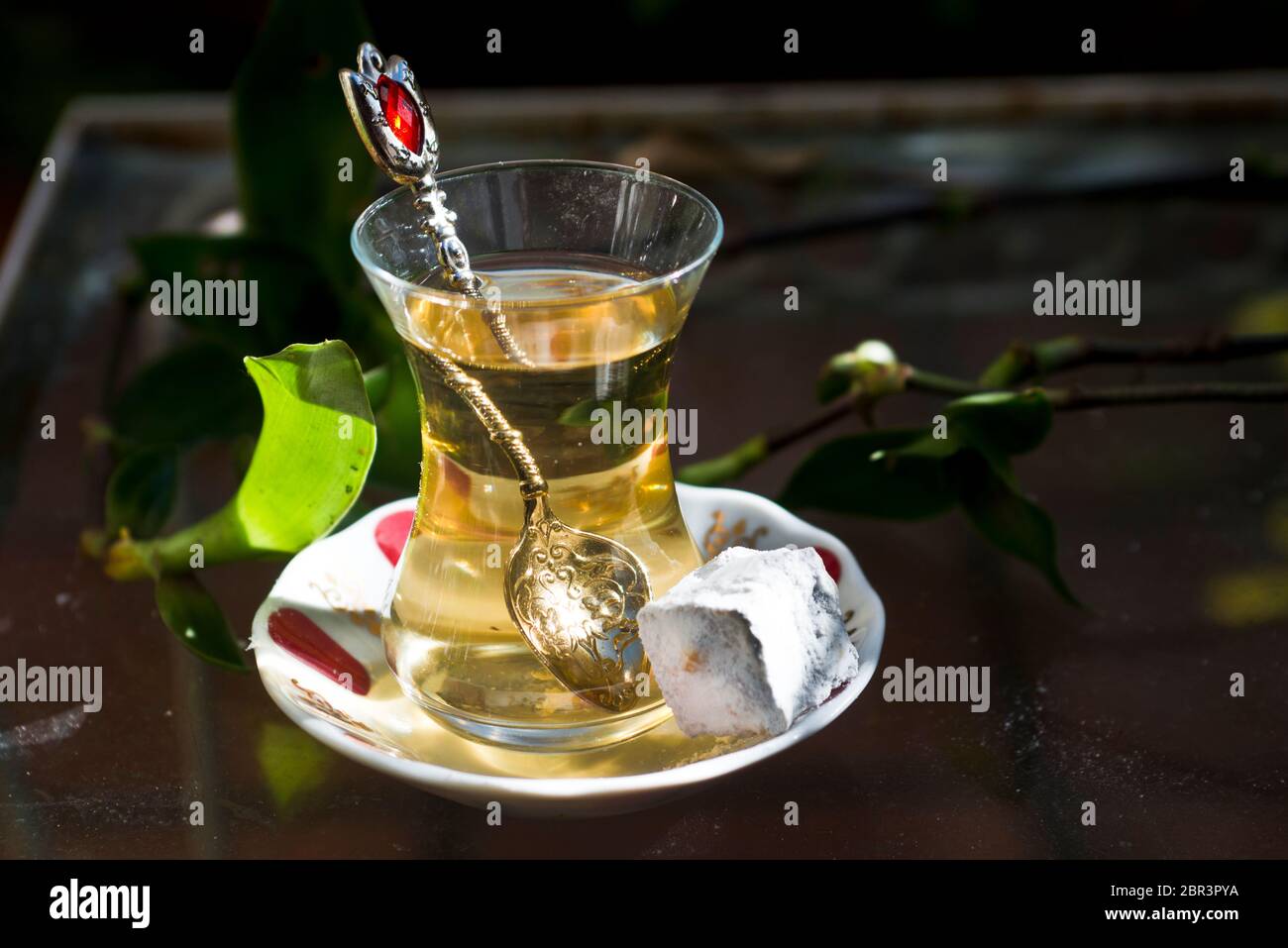 Thé turc aux pommes et doux (délices turcs), servi sur une table en verre dans un jardin Banque D'Images