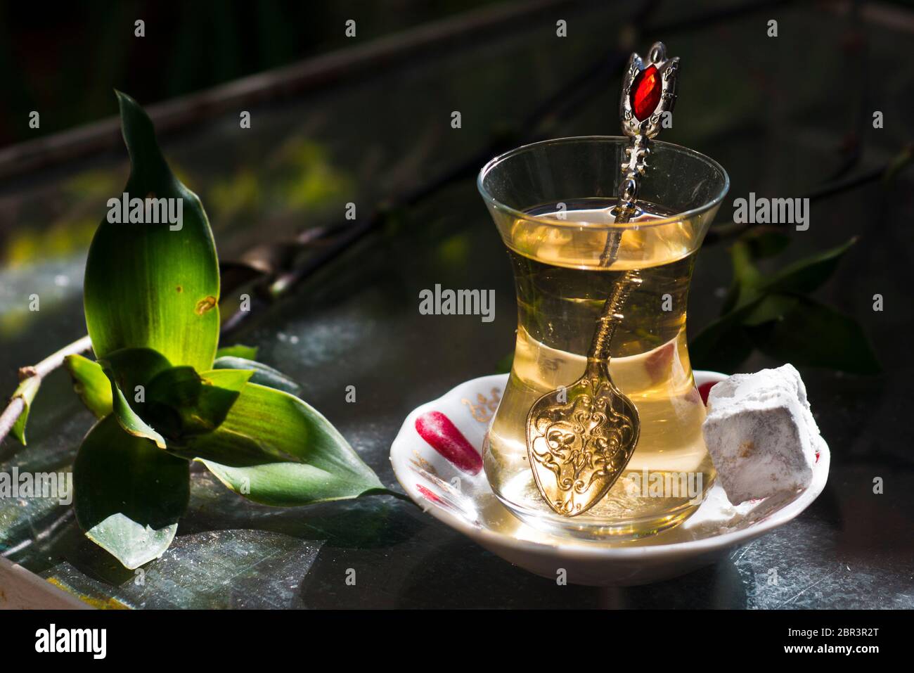 Thé turc aux pommes et doux (délices turcs), servi sur une table en verre dans un jardin Banque D'Images