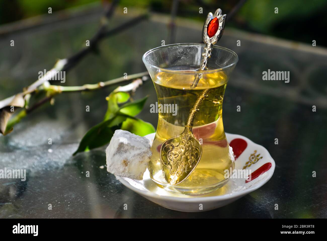 Thé turc aux pommes et doux (délices turcs), servi sur une table en verre dans un jardin Banque D'Images