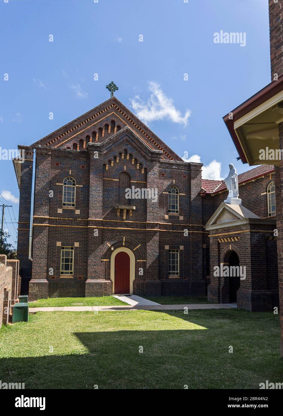 Façade de la chapelle de Notre Dame des Anges construite dans l'architecture romane et ouvert en 1886 dans la ville de Armidale, NSW, Australie. La statue Banque D'Images