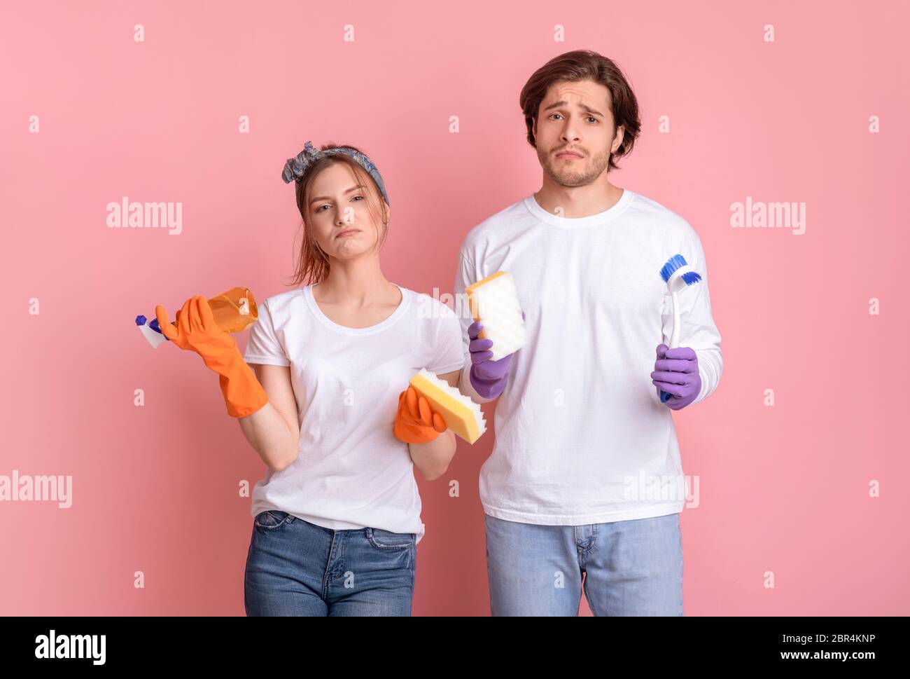 Nettoyage des minerais. Mécontent l'homme et la femme avec des outils ménagers en mains Banque D'Images