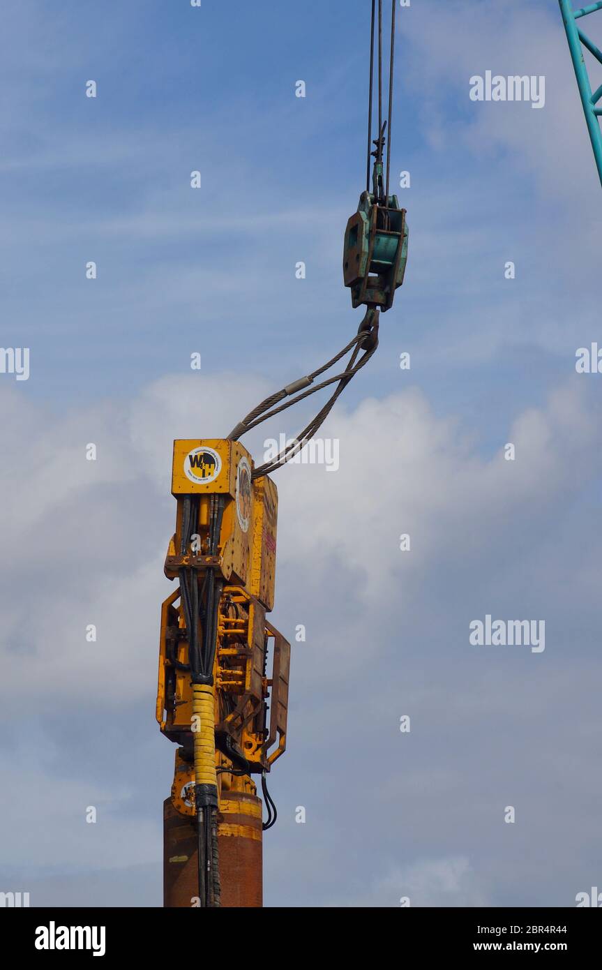 Gros plan d'une grue industrielle soulevant des machines lourdes sur les quais Banque D'Images