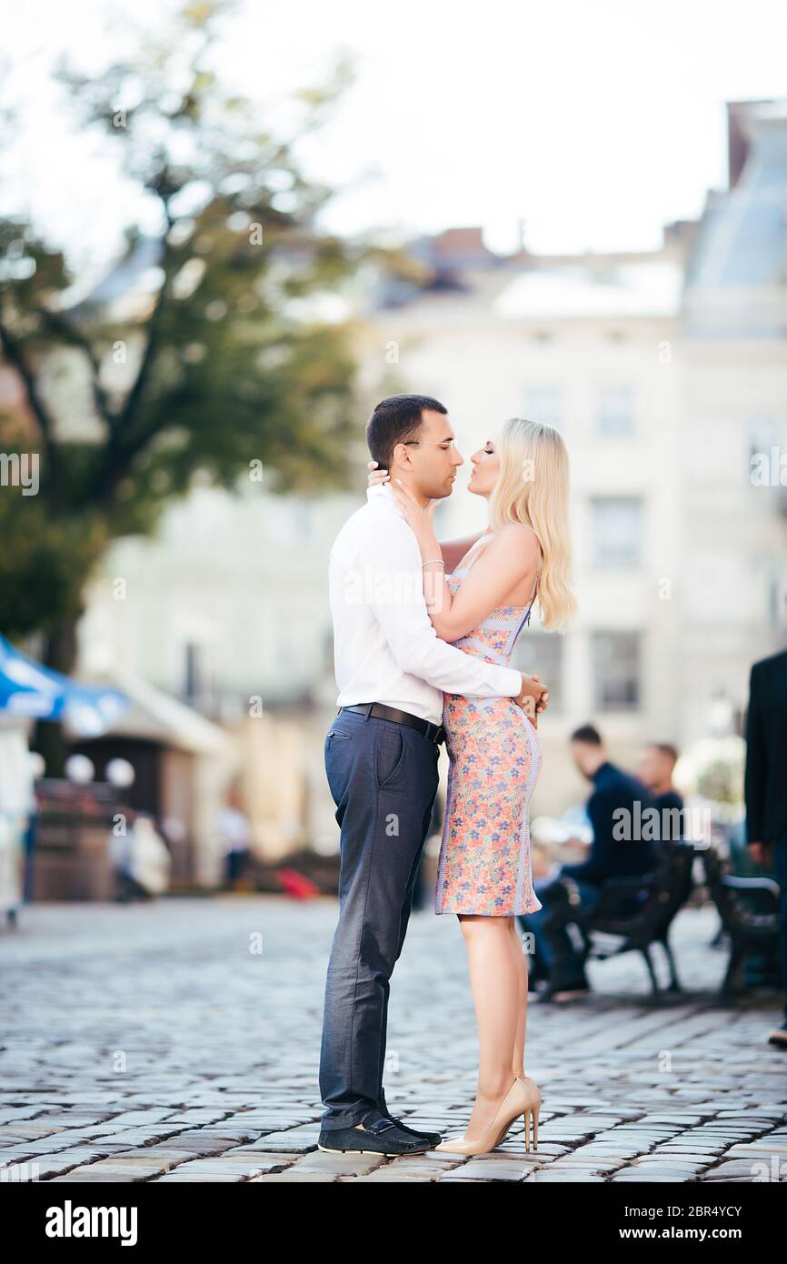 en descendant la rue ensemble. Joyeux jeune homme et femme souriante marchant dans les rues de la vieille ville, Banque D'Images