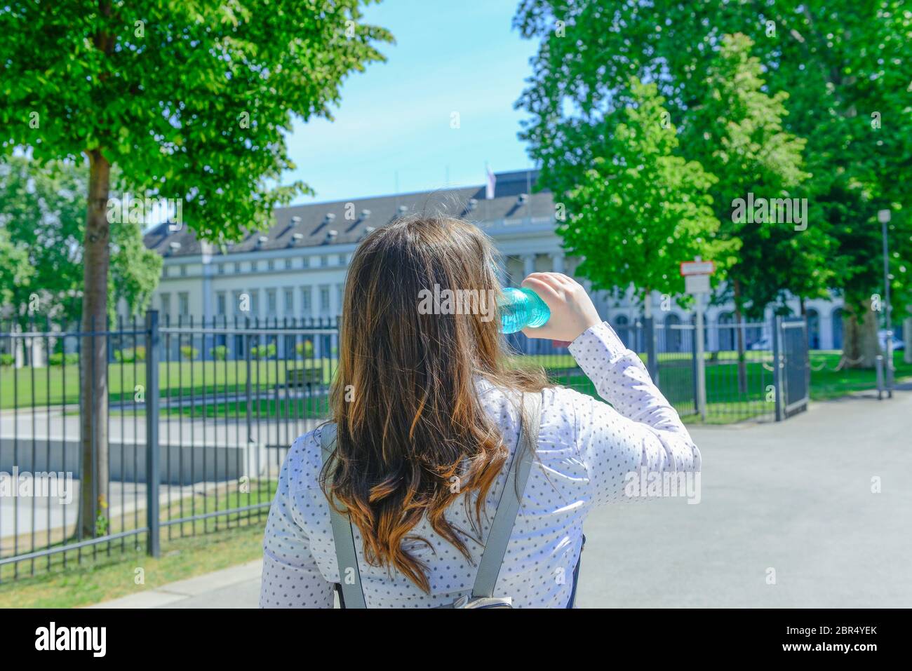 Concept d'hydratation. Une jeune femme d'affaires boit une bouteille d'eau Banque D'Images