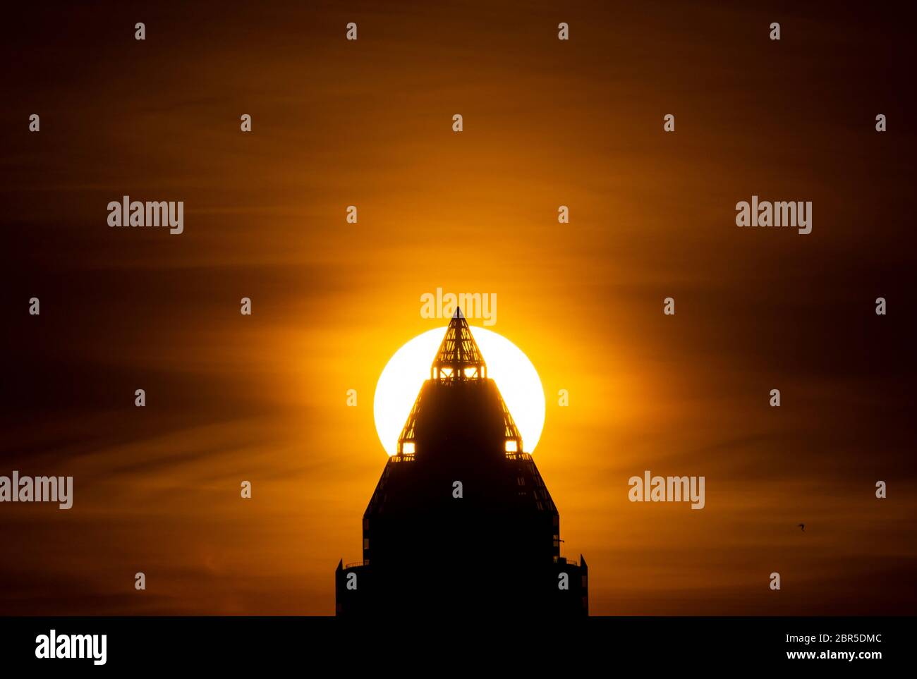 20 mai 2020, Hessen, Francfort-sur-le-main : le soleil se couche derrière le Messeturm. Dans les jours à venir, il y aura un changement entre les nuages et le soleil. Photo : Boris Roessler/dpa Banque D'Images
