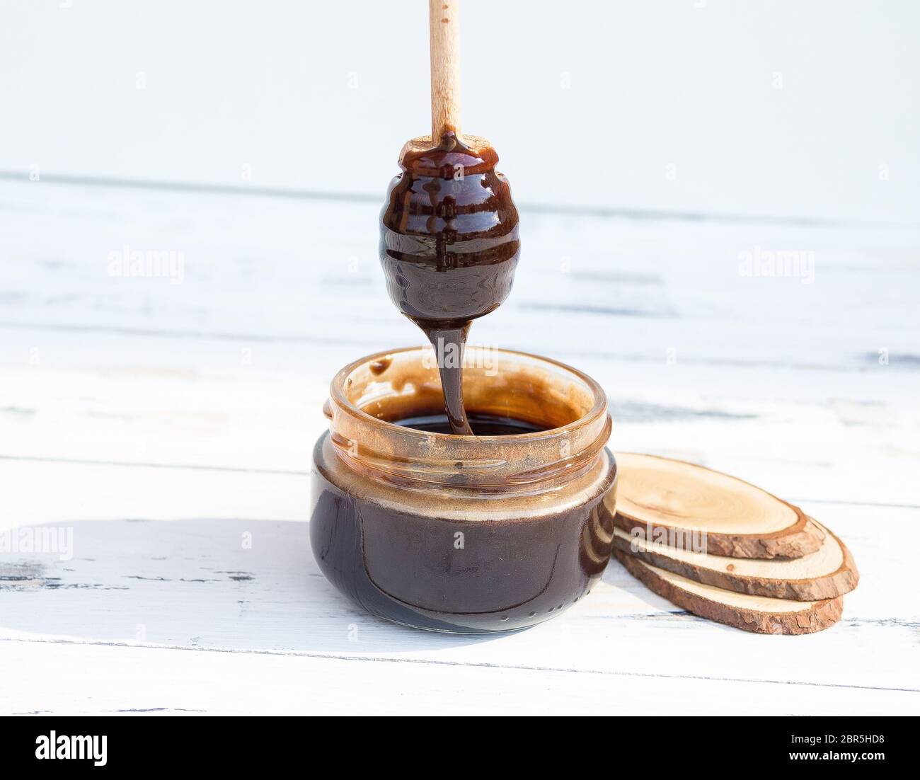 Un pot de dessert au chocolat, miel ou masque cosmétique sur fond blanc en bois. Espace de copie libre. Banque D'Images