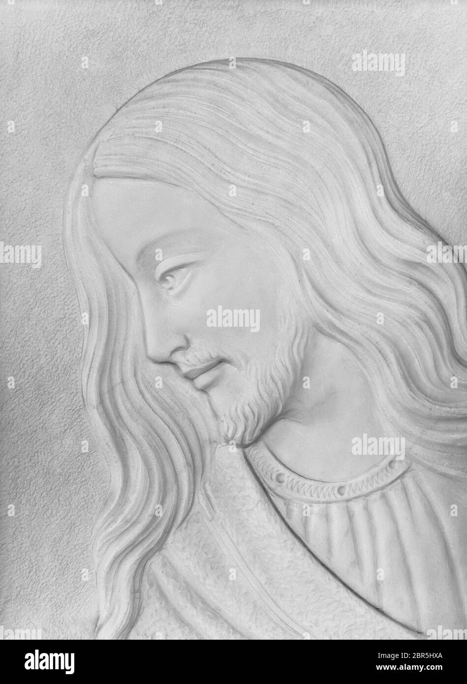 Bas-relief en pierre blanche du Christ souriant. Idéal pour les concepts et les milieux. Banque D'Images
