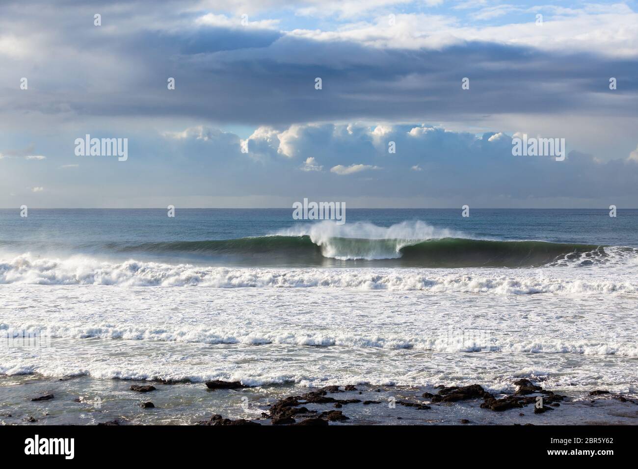 Ocean vagues se briser la puissance de l'eau le long du littoral rocheux de la plage par temps de tempête. Banque D'Images