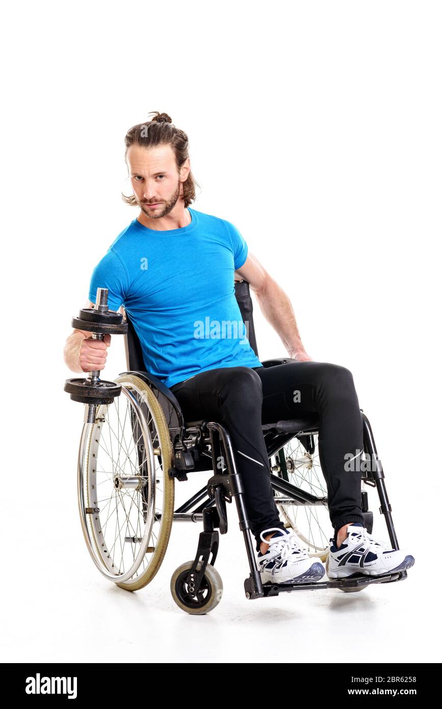 Jeune homme handicapé en fauteuil roulant en train avec bar-bell Banque D'Images