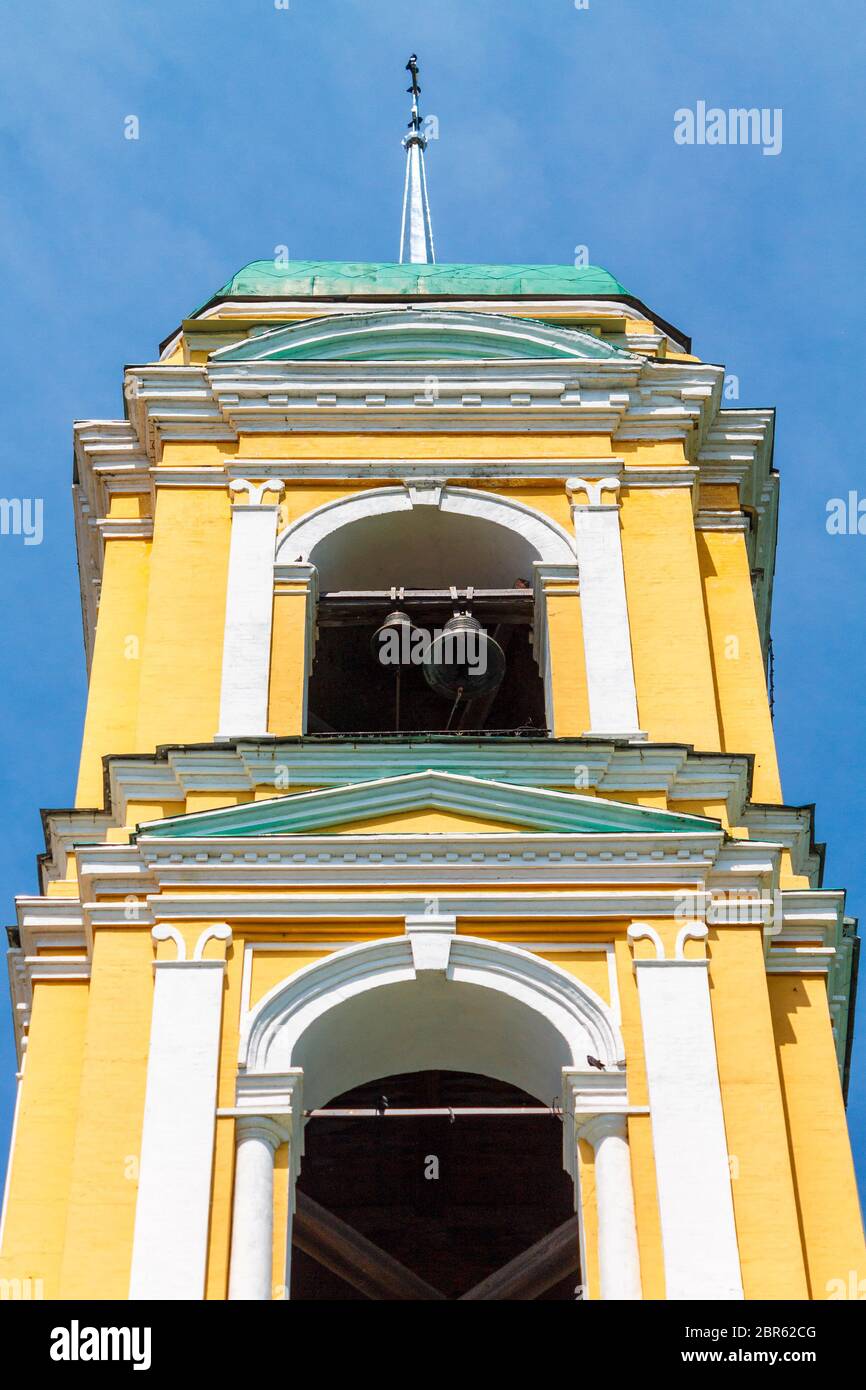 Église chrétienne orthodoxe jaune avec un dôme vert contre un ciel bleu avec des nuages blancs. Banque D'Images