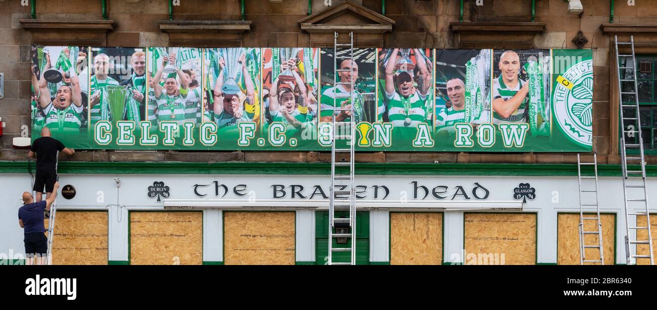Gorbals, Glasgow, Écosse, Royaume-Uni. 20 mai 2020. Malgré sa fermeture en raison de la pandémie du coronavirus, le Brazen Head a toujours célébré le fait que le Celtic devenait champion écossais de la création pour la 9e saison consécutive. La photo montre la bannière « Celtic F.C 9 in a Row » avec un collage de photos Scott Brown montrant le capitaine levant le trophée chaque année entre 2012 et 2020 étant érigée comme les locaux à l'attention de Credit: Kay Roxby/Alay Live News Banque D'Images