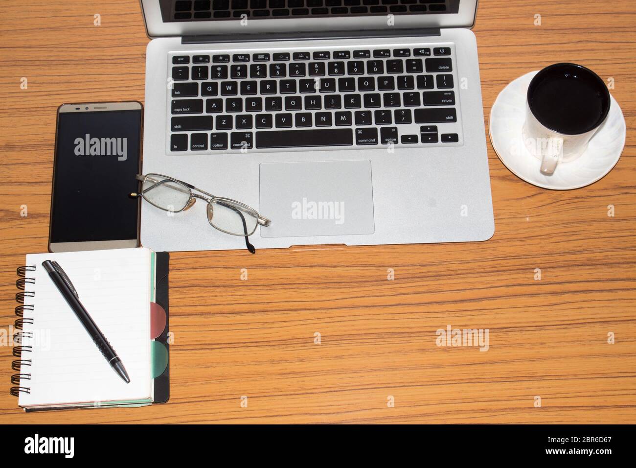 Bureau avec ordinateur portable ouvert, téléphone portable, lunettes, stylo et une tasse de café. Vue de dessus avec l'exemplaire de l'espace. Concept d'affaires vie encore avec office stuff o Banque D'Images