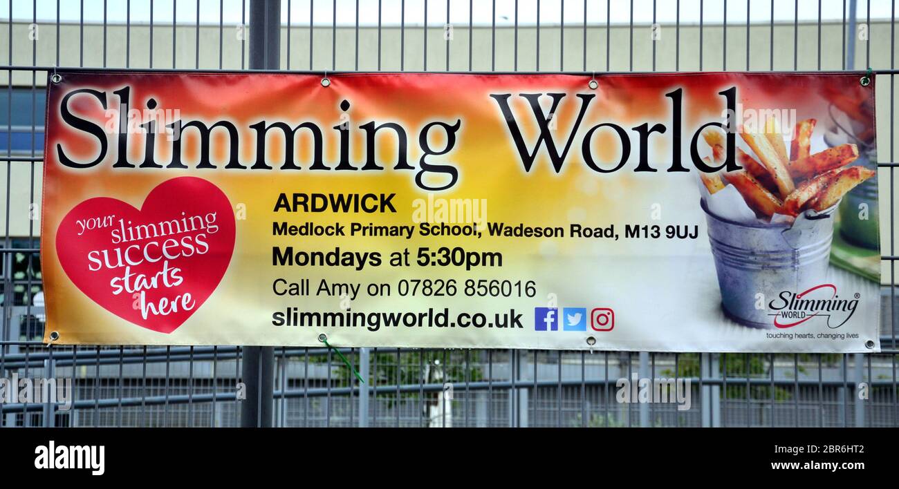 Une bannière sur une clôture pour annoncer Slimming World à Manchester, Angleterre, Royaume-Uni. Minceur World court des groupes pour essayer d'aider les gens à perdre du poids. Banque D'Images
