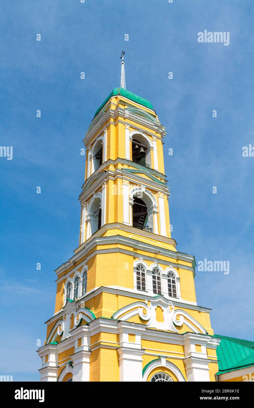 Église chrétienne orthodoxe jaune avec un dôme vert contre un ciel bleu avec des nuages blancs. Banque D'Images