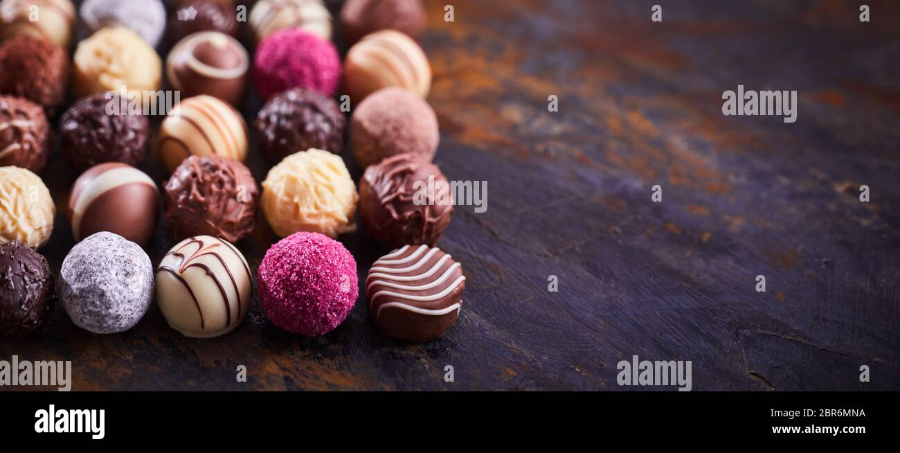 Bannière avec Panorama chocolat Pralines de luxe parfaitement disposées en rangées sur bois rustique avec copie espace et peu profondes 6 Banque D'Images