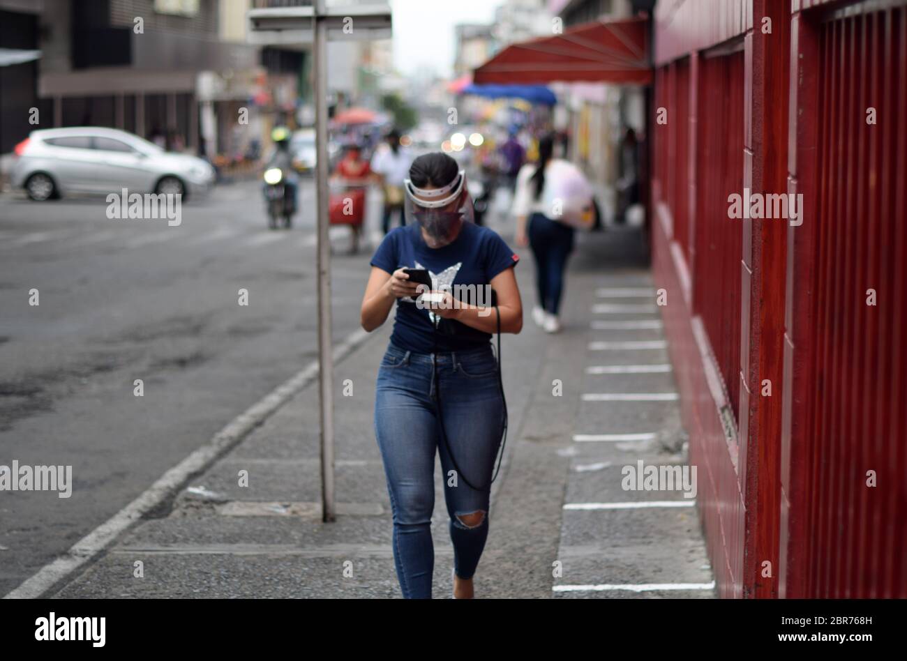 Une jeune femme marche dans la rue pendant l'épidémie de coronavirus en Colombie Banque D'Images