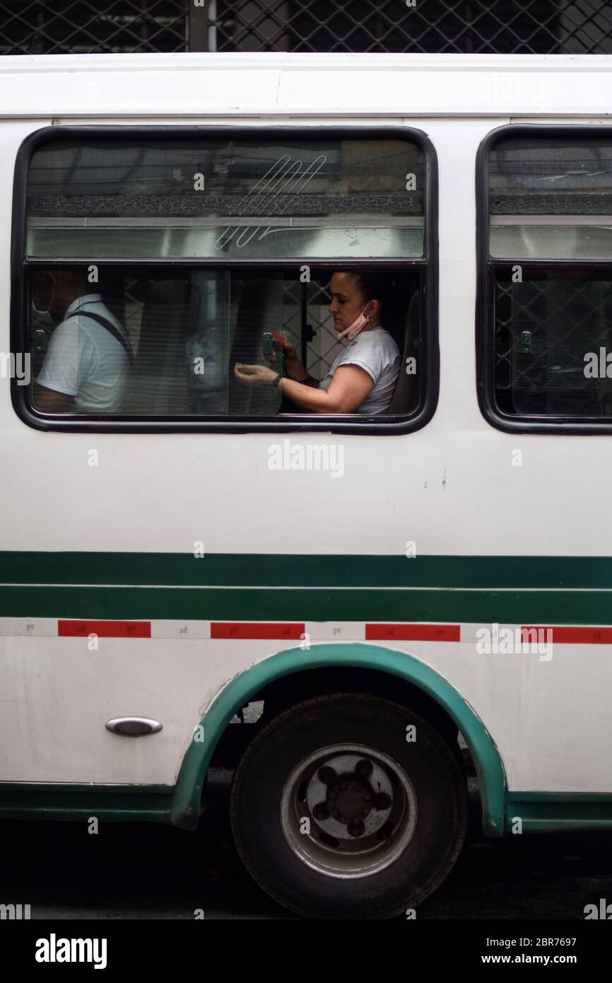 Une femme désinfecte les mains dans un autobus public pendant l'épidémie de coronavirus en Colombie Banque D'Images