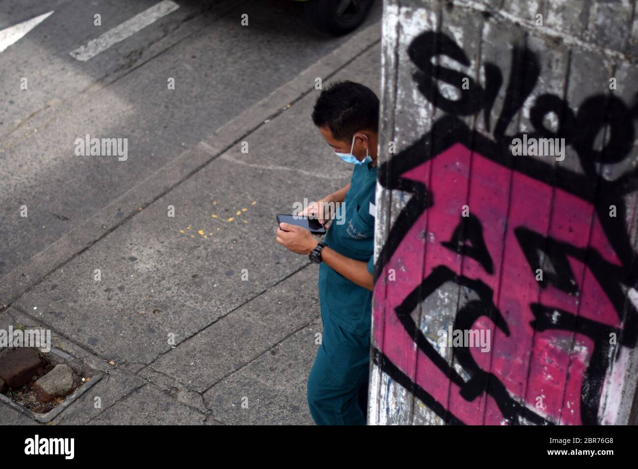 Homme utilisant son smartphone dans la rue pendant l'épidémie de coronavirus en Colombie Banque D'Images