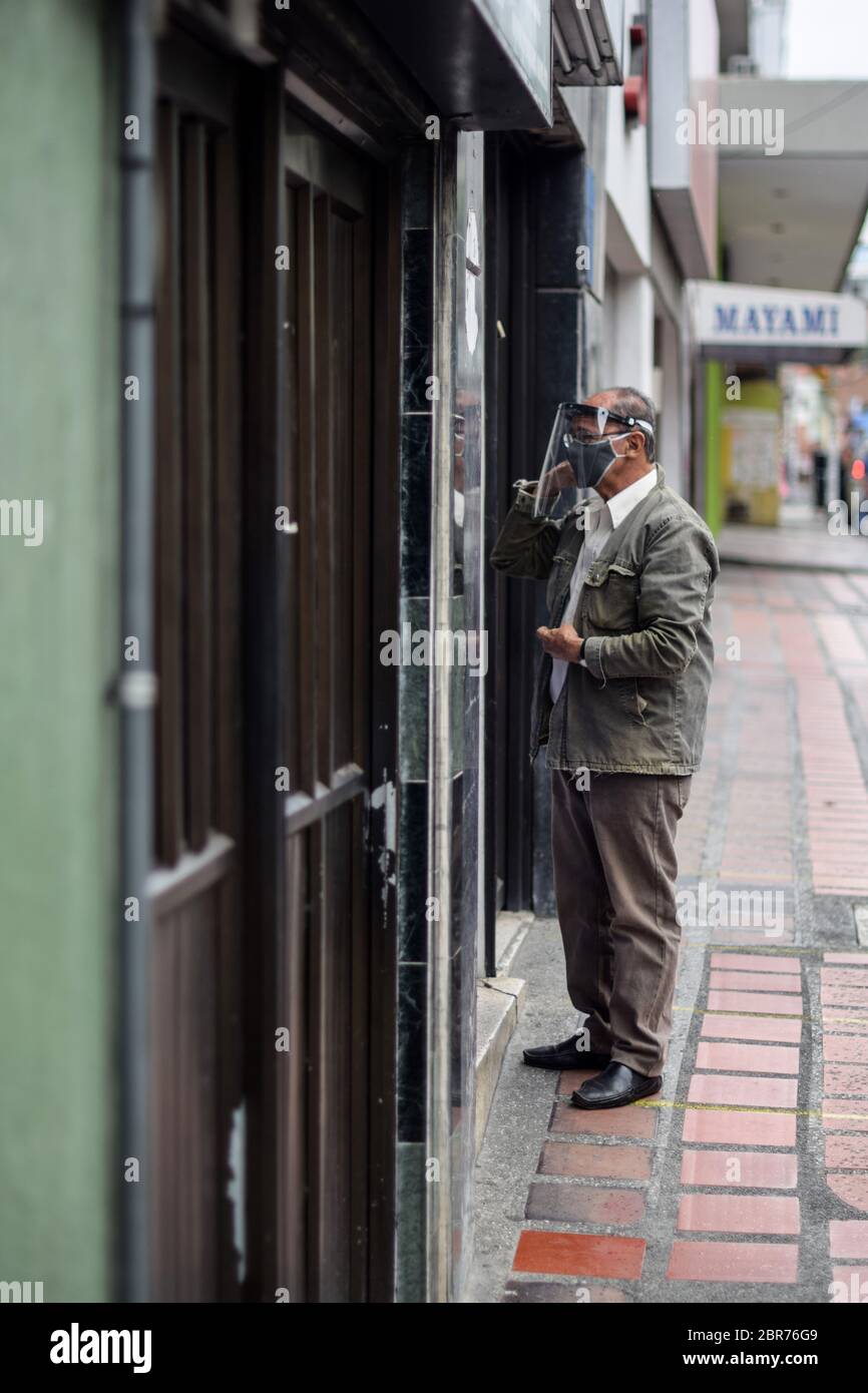 Homme âgé dans la rue avec toute la protection du visage pendant l'épidémie de coronavirus en Colombie Banque D'Images