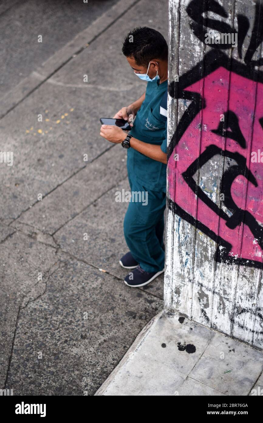 Homme utilisant son smartphone dans la rue pendant l'épidémie de coronavirus en Colombie Banque D'Images