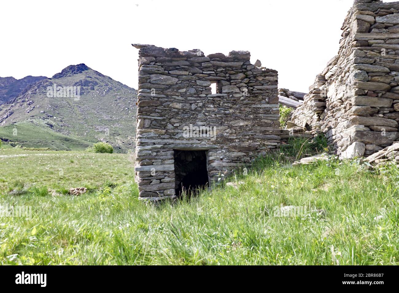 Photo rognée d'une ancienne cabane de montagne avec les Alpes italiennes en arrière-plan Banque D'Images