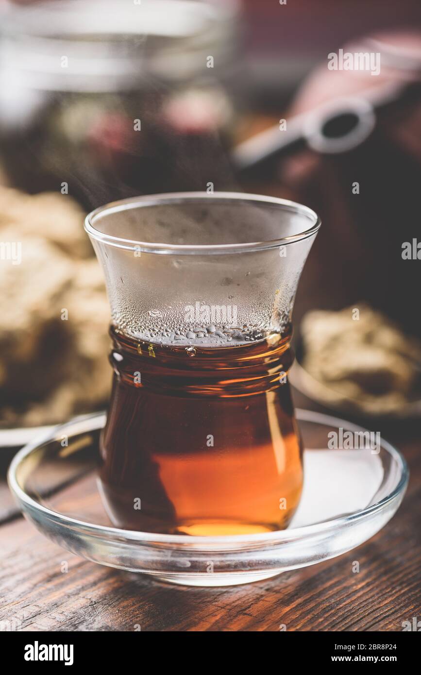 Armudu verre avec le thé noir avec des ustensiles de cuisine sur l'arrière-plan Banque D'Images