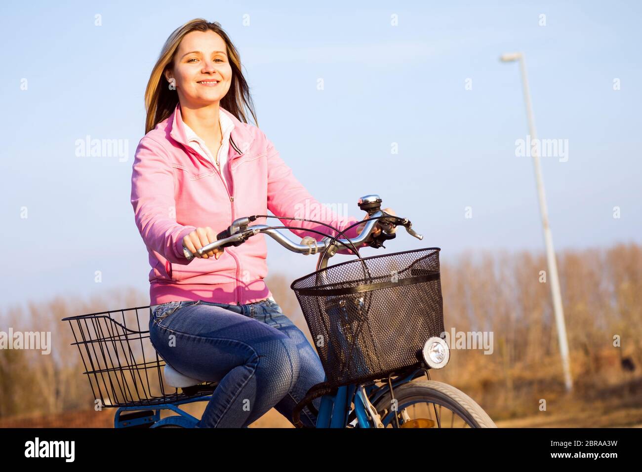 Belle femme souriante est sur vélo dehors, active concept de vie. Banque D'Images