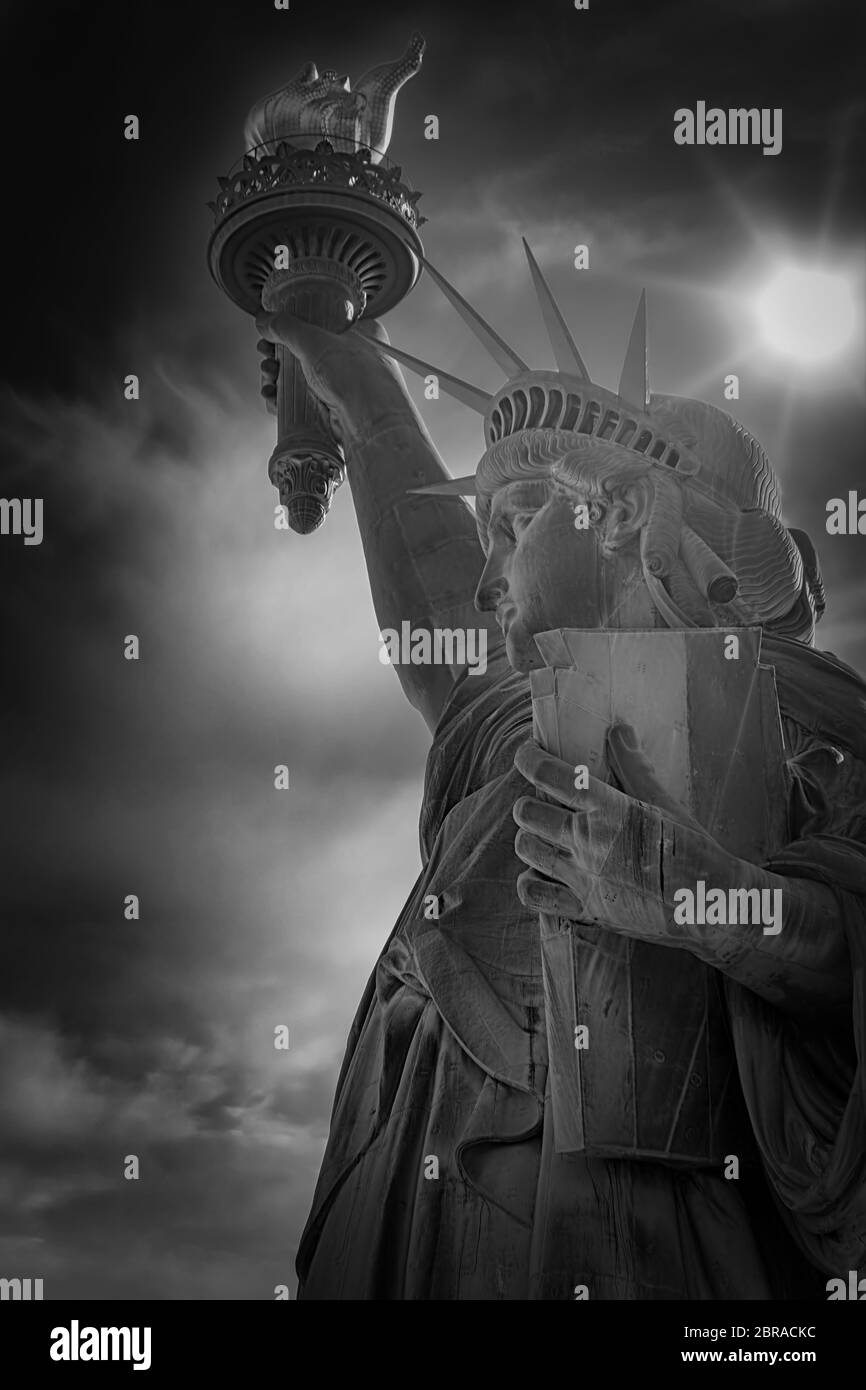 Le soleil brille de derrière la Statue de la liberté à New York. Banque D'Images
