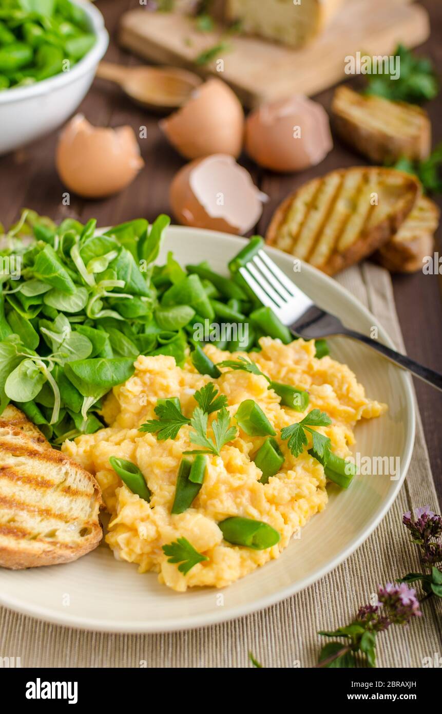 Oeufs brouillés avec des haricots et de la salade, cuit sur une baguette panini Banque D'Images