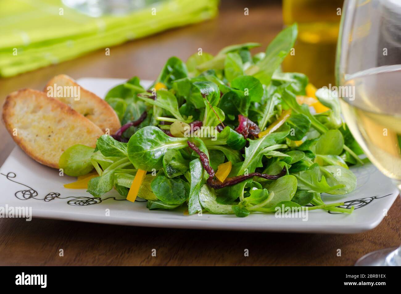 Salade de roquette, laitue d'agneau, poivrons et oignons caramélisés. L'huile d'olive croustillant de boulangerie baguettes Banque D'Images