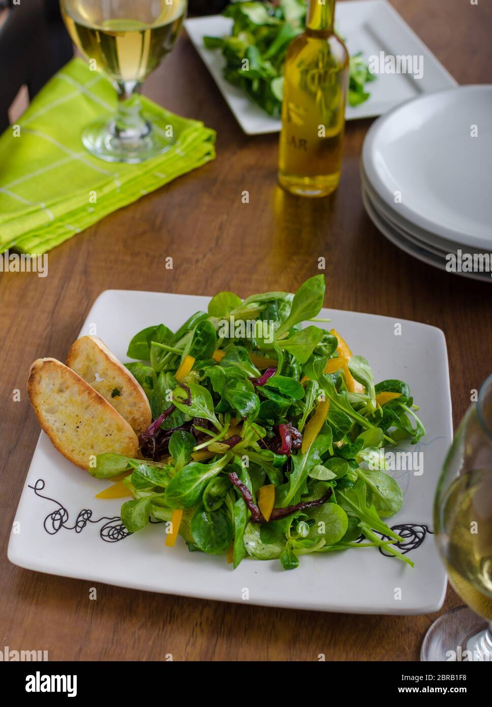 Salade de roquette, laitue d'agneau, poivrons et oignons caramélisés. L'huile d'olive croustillant de boulangerie baguettes Banque D'Images